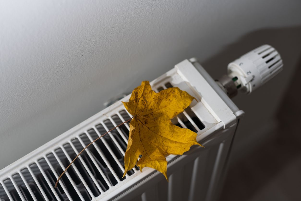 Heating unit with autumn leaf on white background, the concept of saving