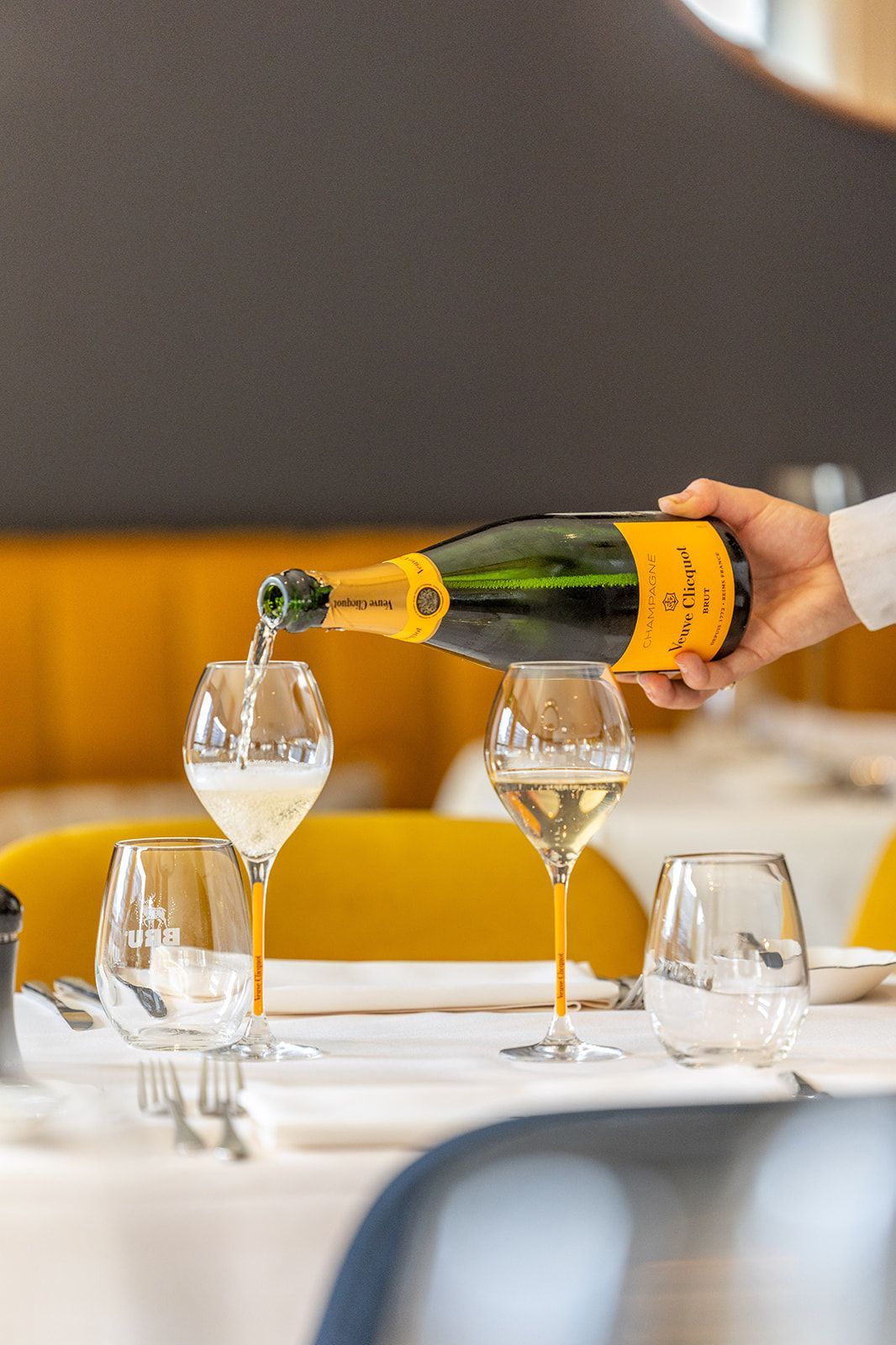 A white two-story brick building with a dark sculpture in the front yard featuring the text 
