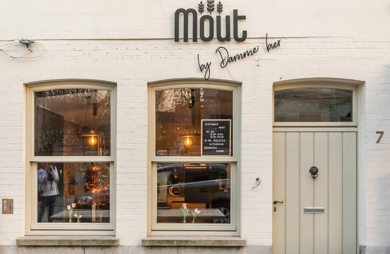 A gold Land Rover displayed inside a room with brick walls, with the text 