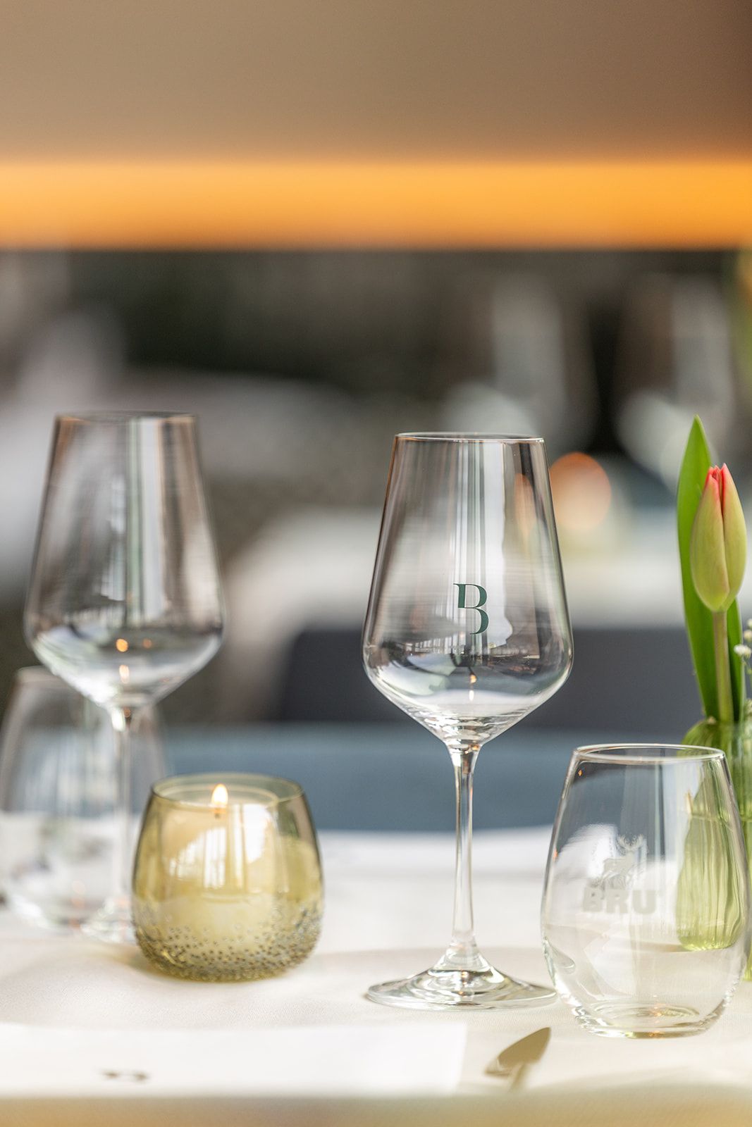 A white door frame looking into a room with a dark-wood fireplace, a dining table with yellow chairs, and tiled floors.