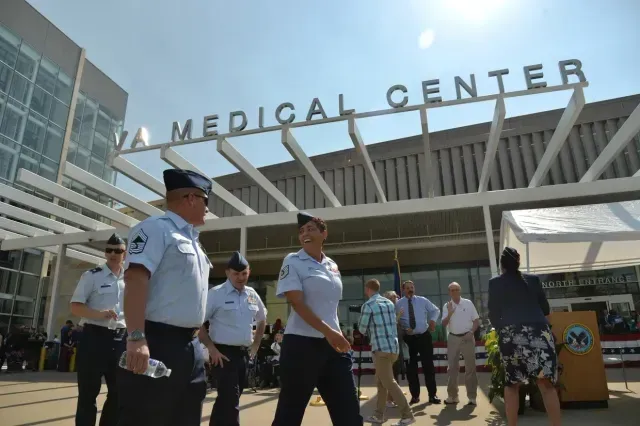 A group of people are walking in front of a medical center