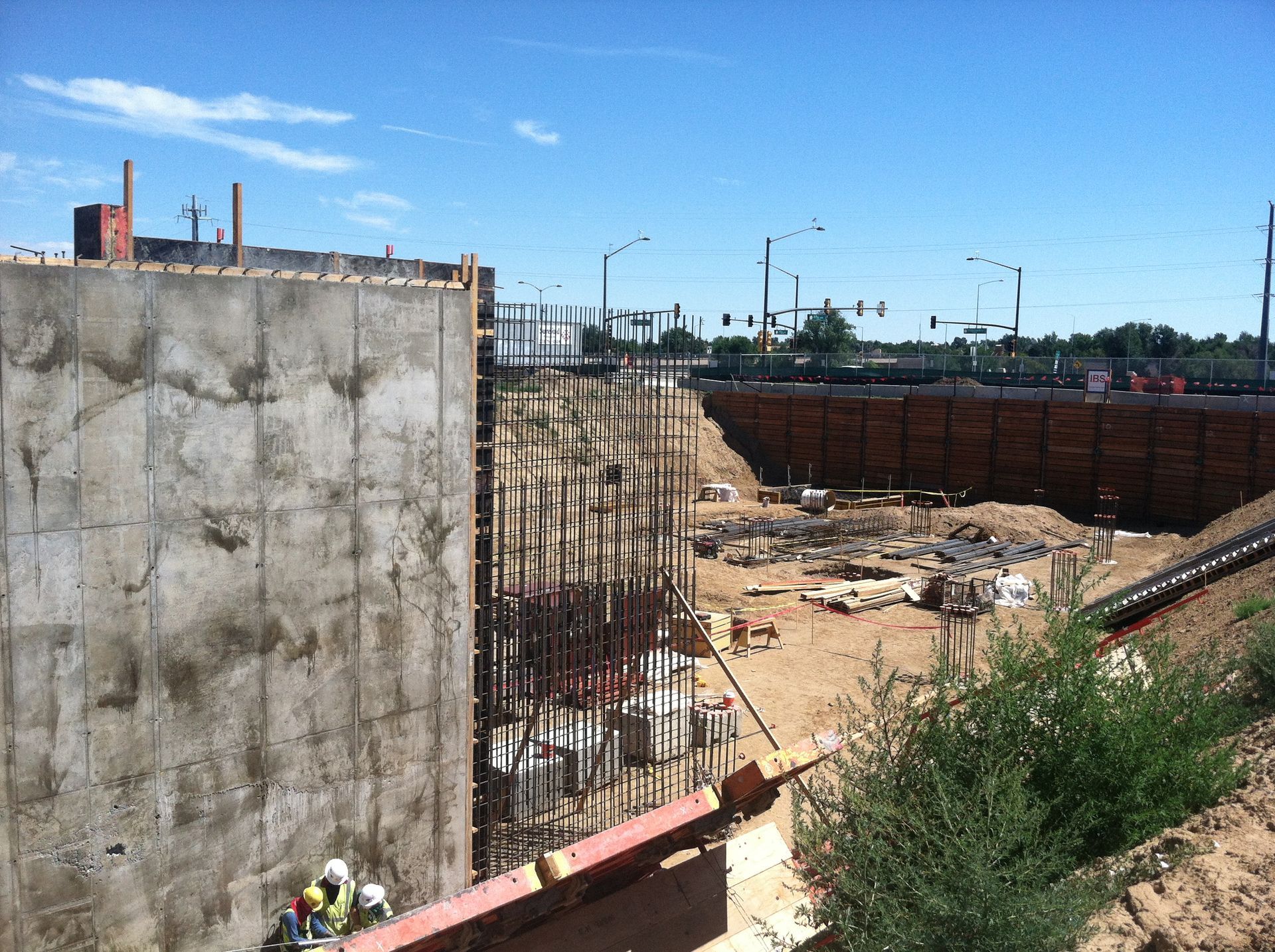 A construction site with a large concrete wall in the foreground