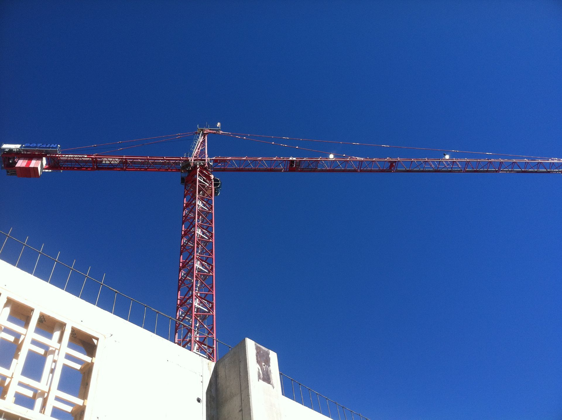 A large red crane is against a blue sky