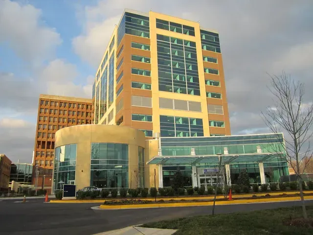 A large building with a lot of windows is surrounded by other buildings