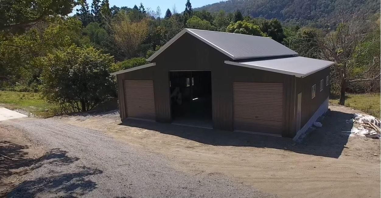 An aerial view of a garage in the middle of a dirt road.