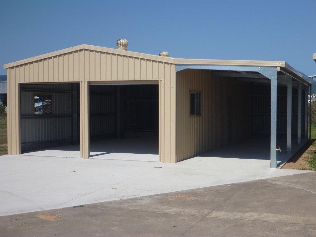 A large metal building with two garage doors and a covered driveway