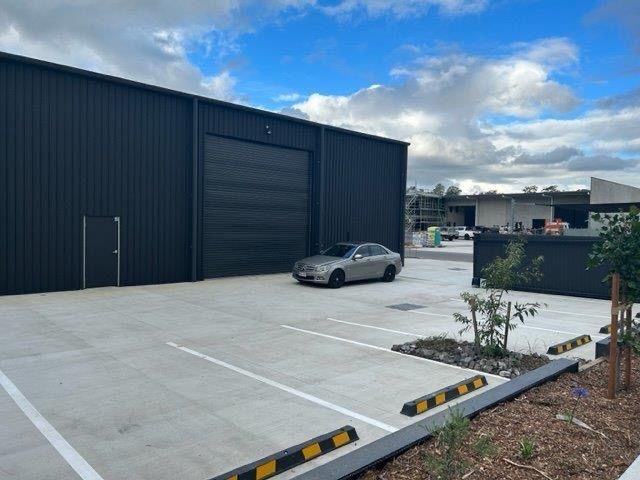 A car is parked in a parking lot in front of a building.