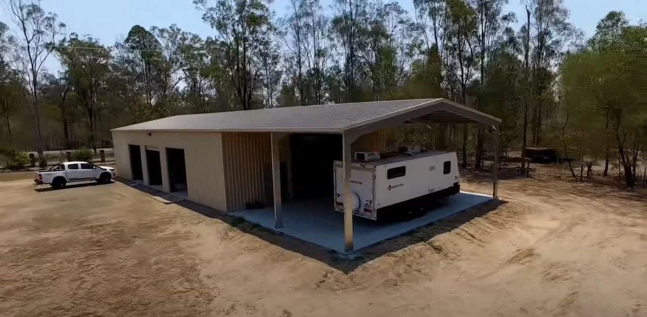 An aerial view of a garage with a trailer inside of it.