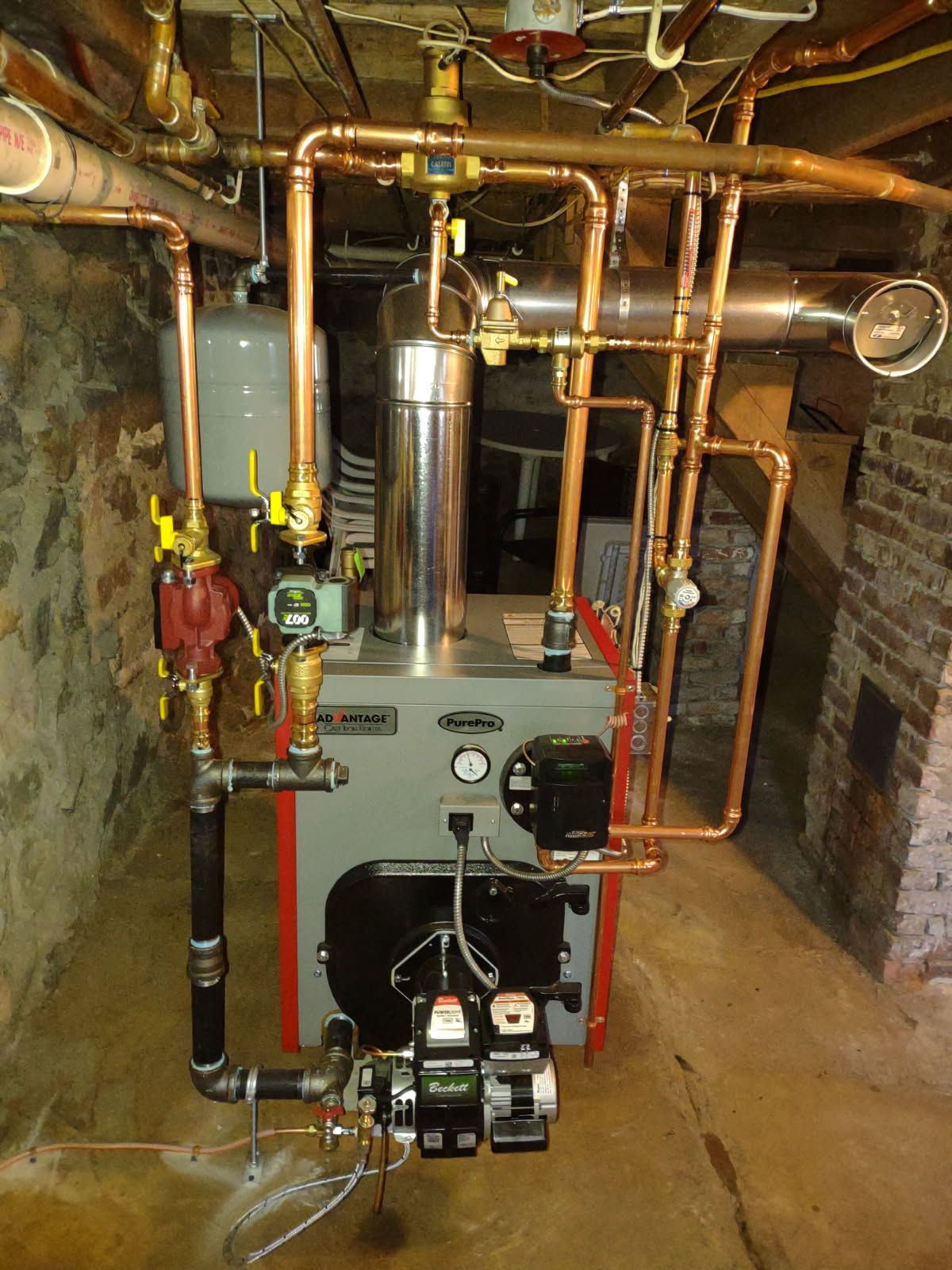 A boiler in a basement with copper pipes