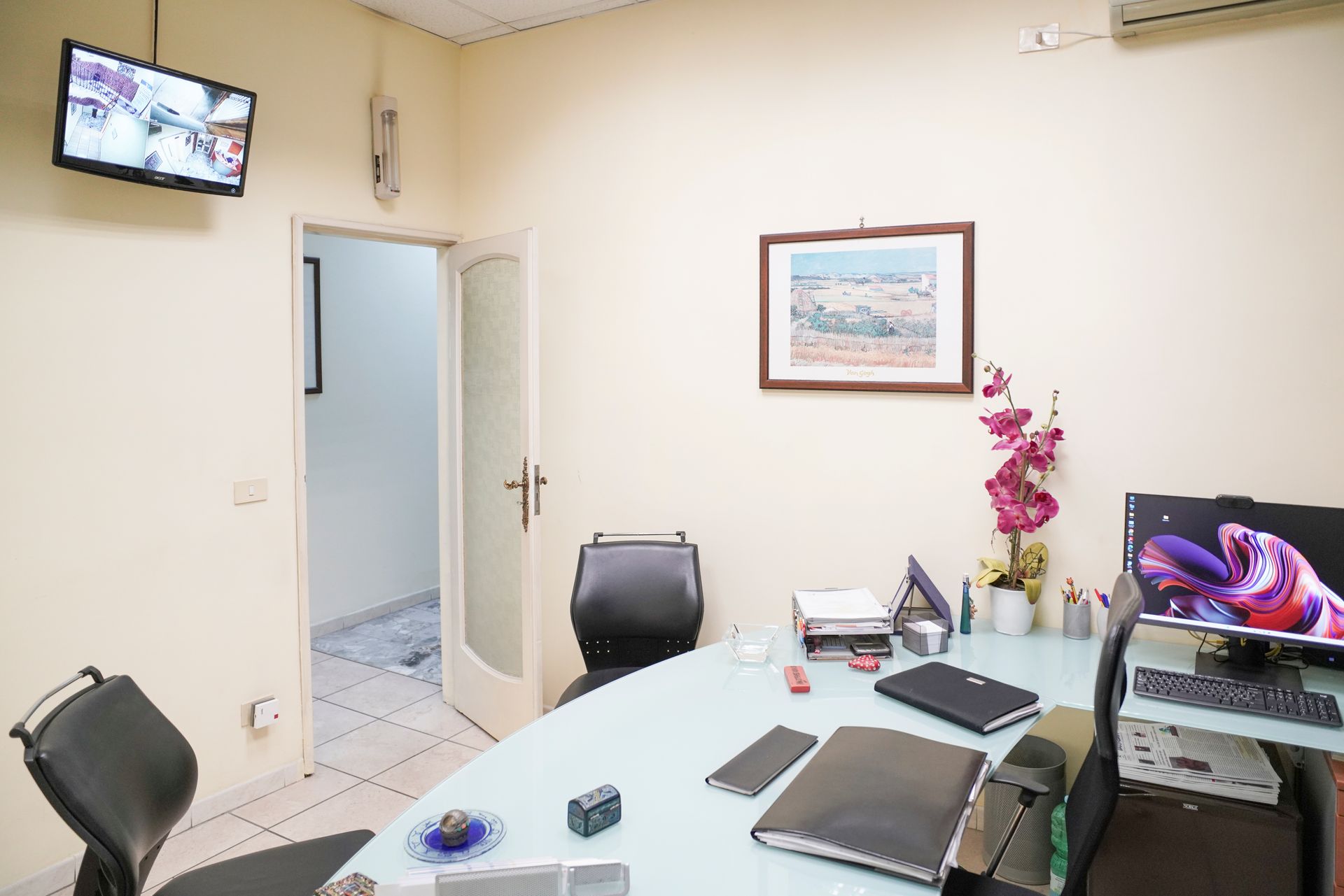 Una stanza con un tavolo e delle sedie e una tv sul muro