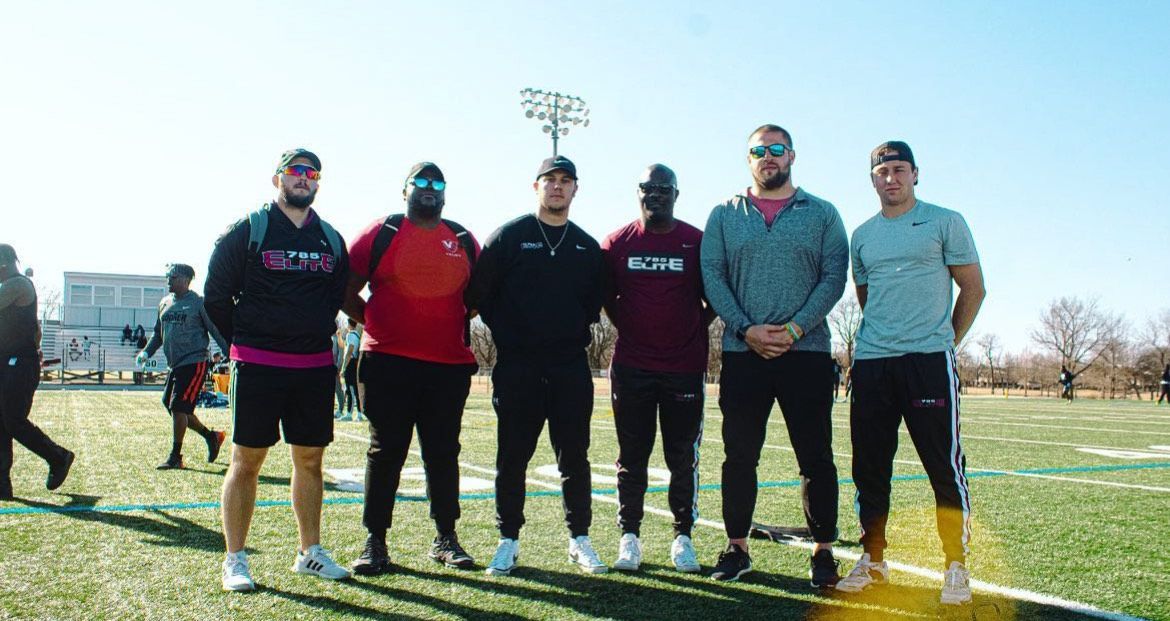 A group of men are standing next to each other on a football field.
