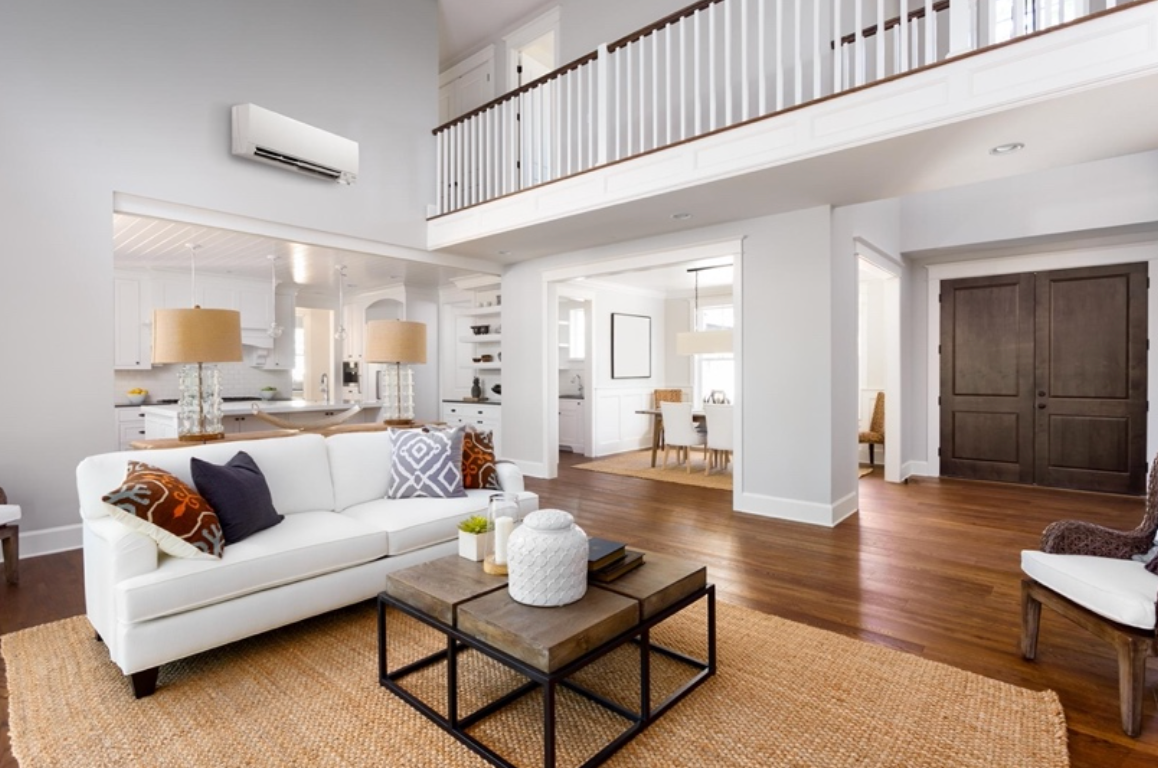 A living room with a white couch , two coffee tables , and a balcony.