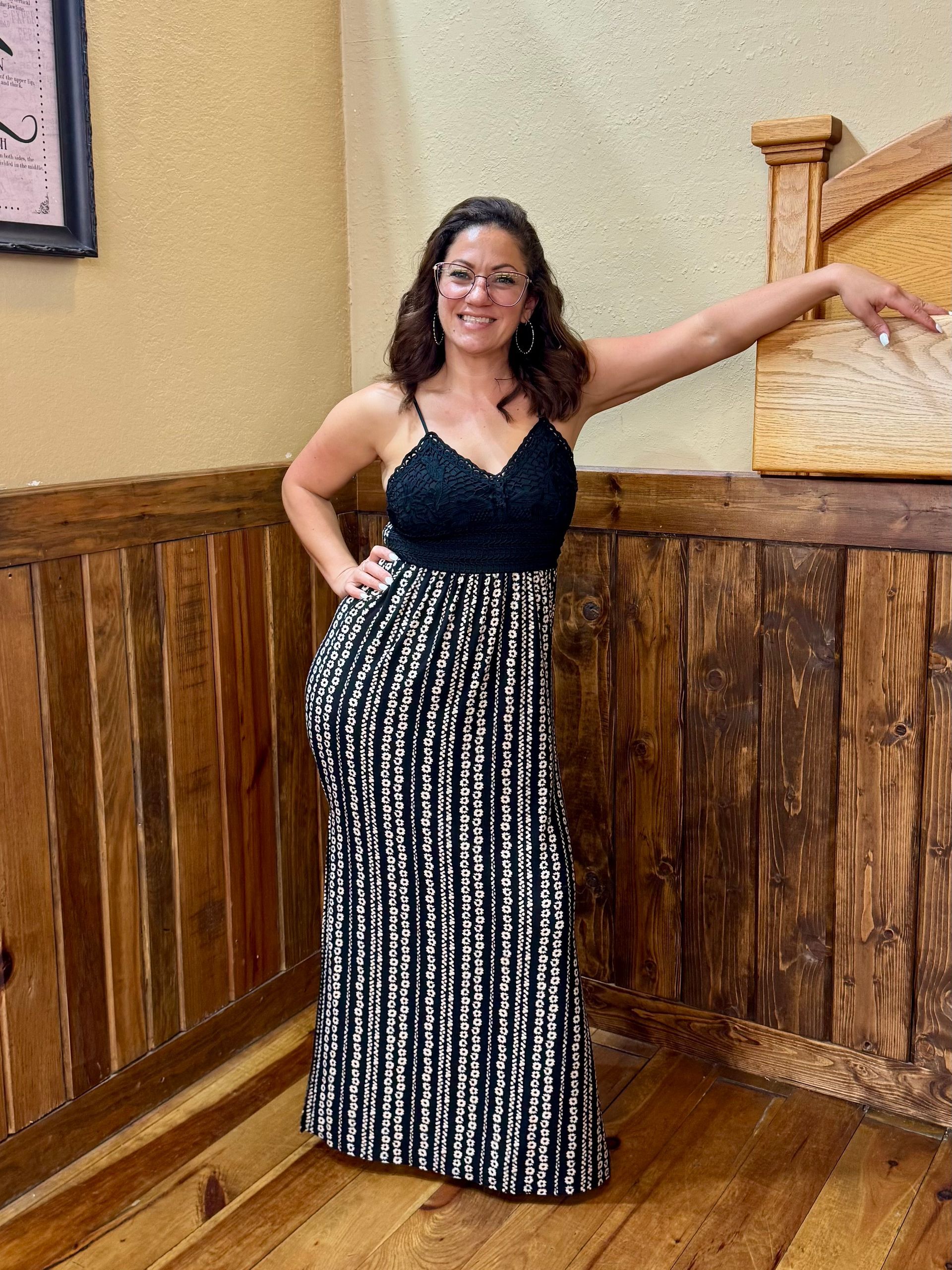 Woman in eyeglasses, white shirt, black pants, in a barber shop.