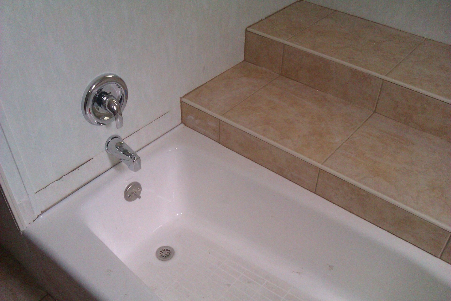 A bathtub in a bathroom next to stairs