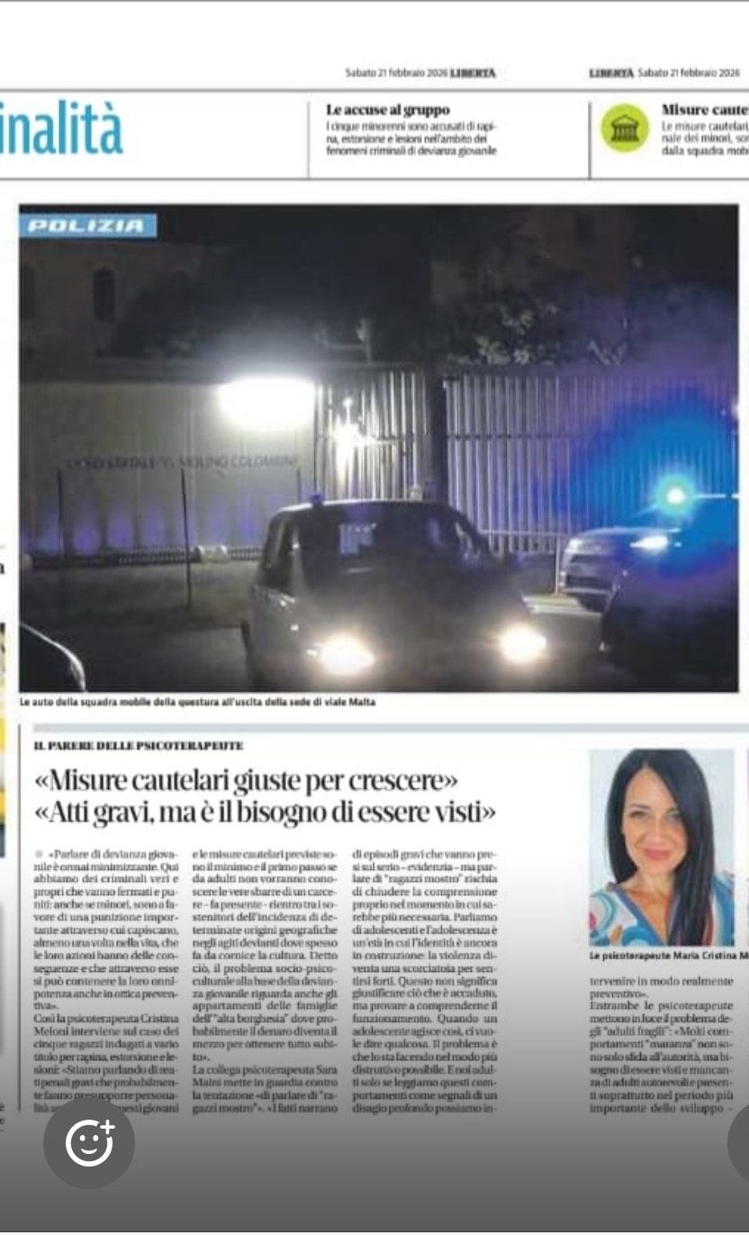 Un'auto della polizia con i fari accesi davanti a un edificio di notte, accanto a un articolo di giornale con il ritratto di una donna.
