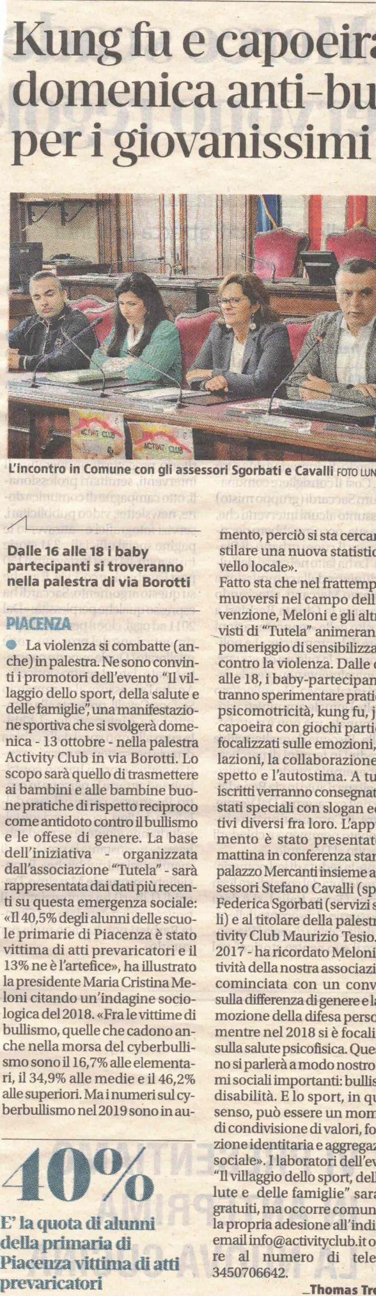 Un ritaglio di giornale con la foto di un gruppo seduto a un tavolo, accompagnato da un testo sulle arti marziali giovanili e sulla lotta al bullismo.