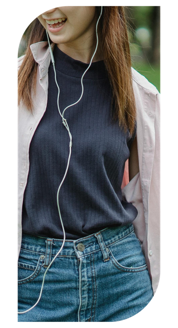 A woman wearing headphones and a pink jacket is smiling.