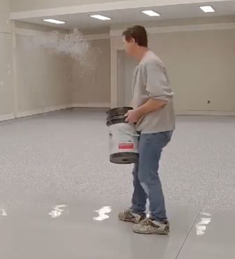 Epoxy flooring contractor applying a decorative coating system to a residential garage floor in Madison, Alabama.
