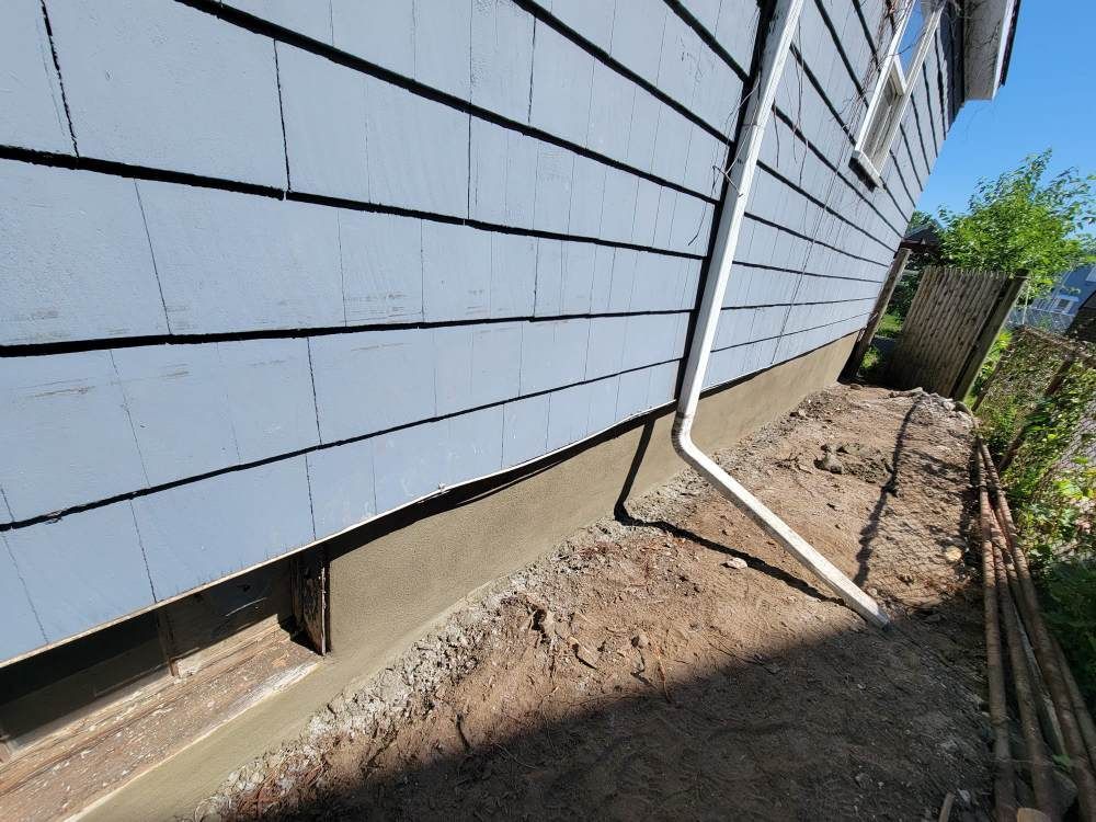 A house with a drain pipe on the side of it.