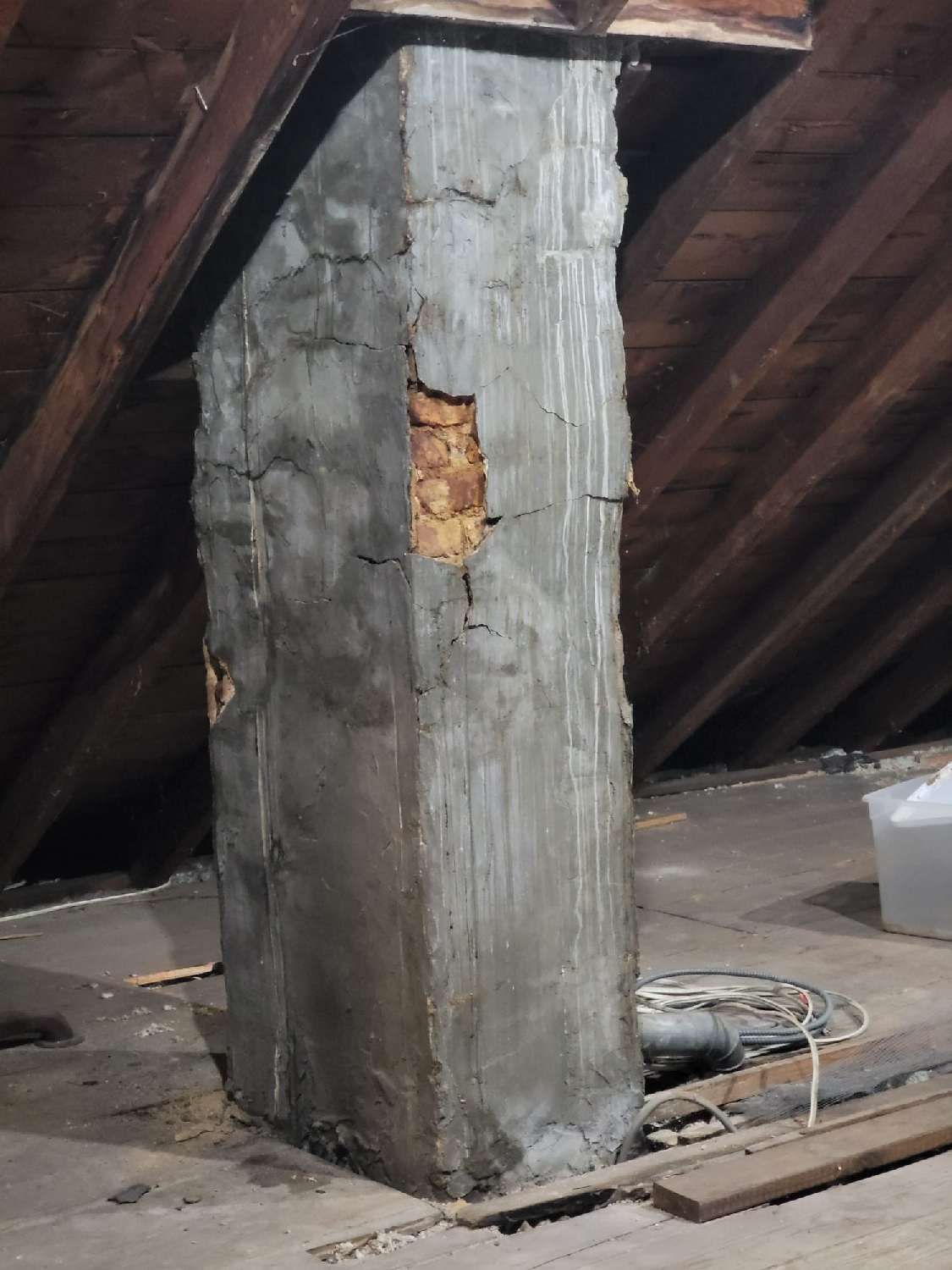 A chimney is sitting in the attic of a house.