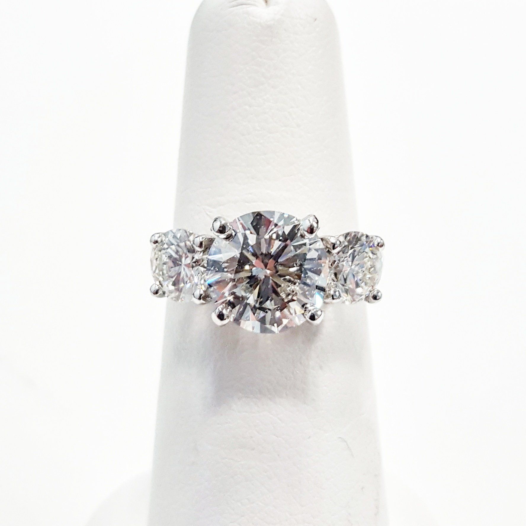 A diamond ring is sitting on a white finger.