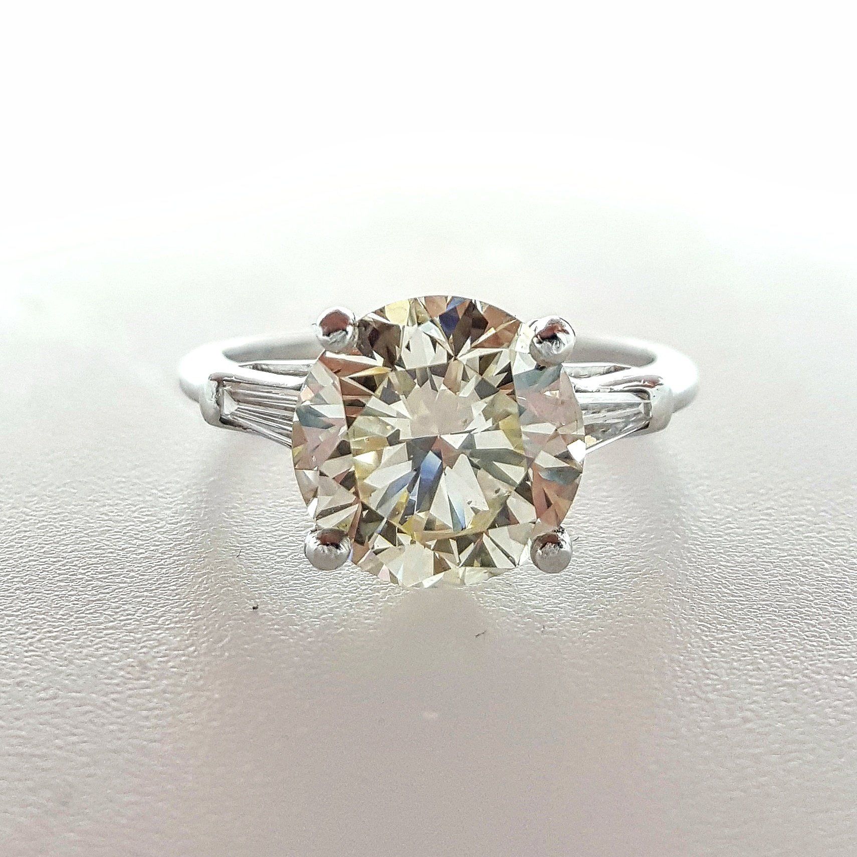 A diamond ring is sitting on a white surface.