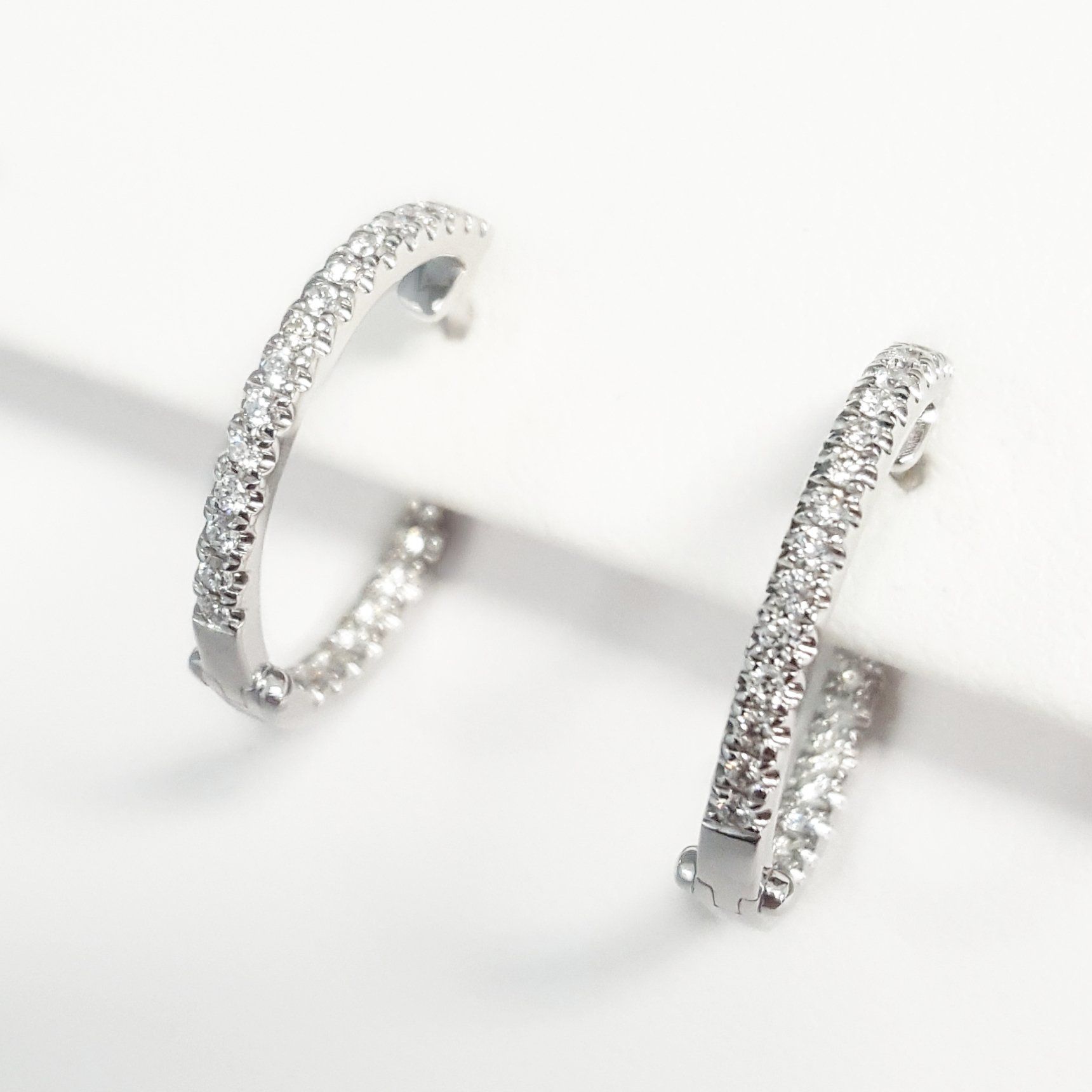 A pair of hoop earrings are sitting on a white surface.