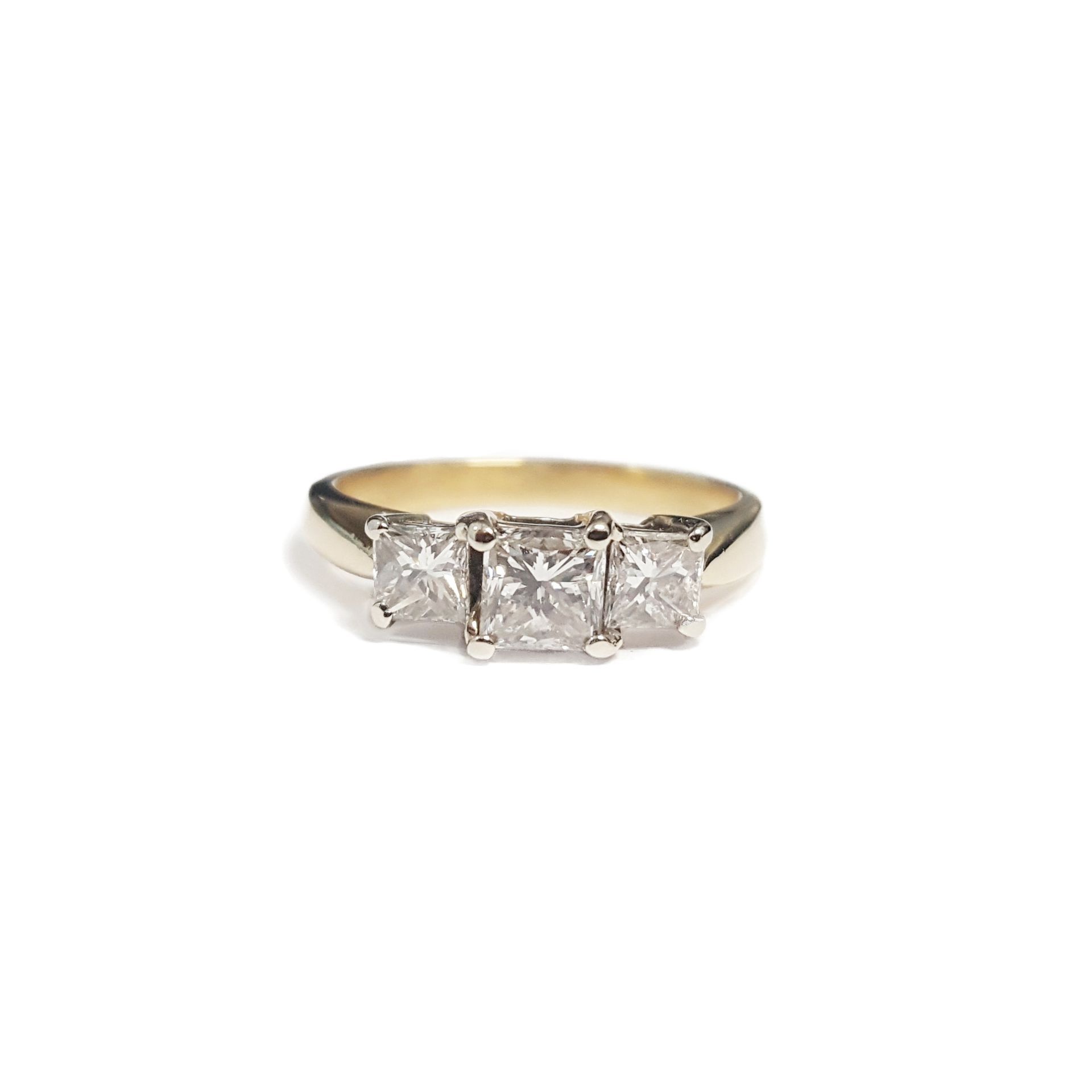 A yellow gold ring with three square diamonds on a white background.
