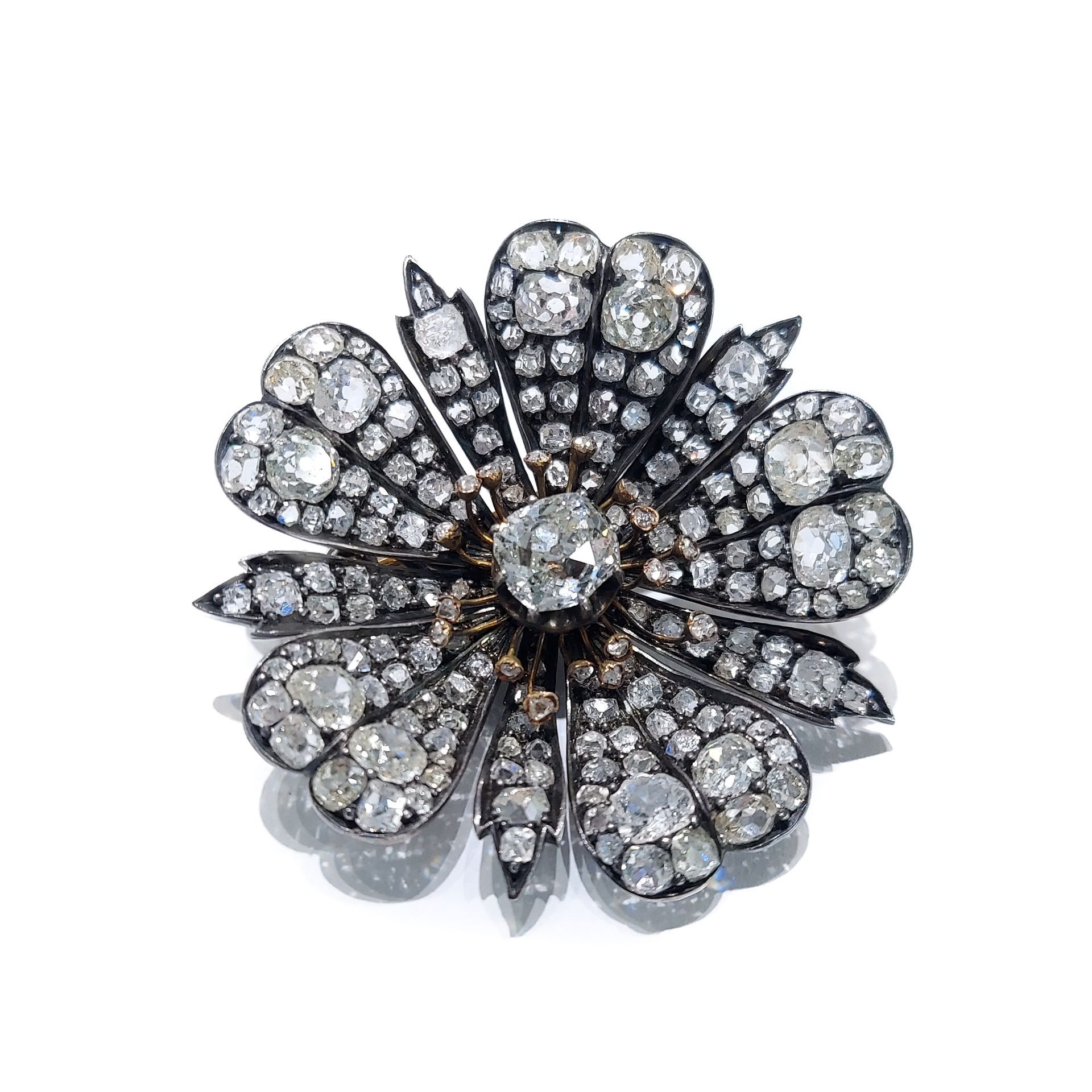 A brooch in the shape of a flower with diamonds on a white background.