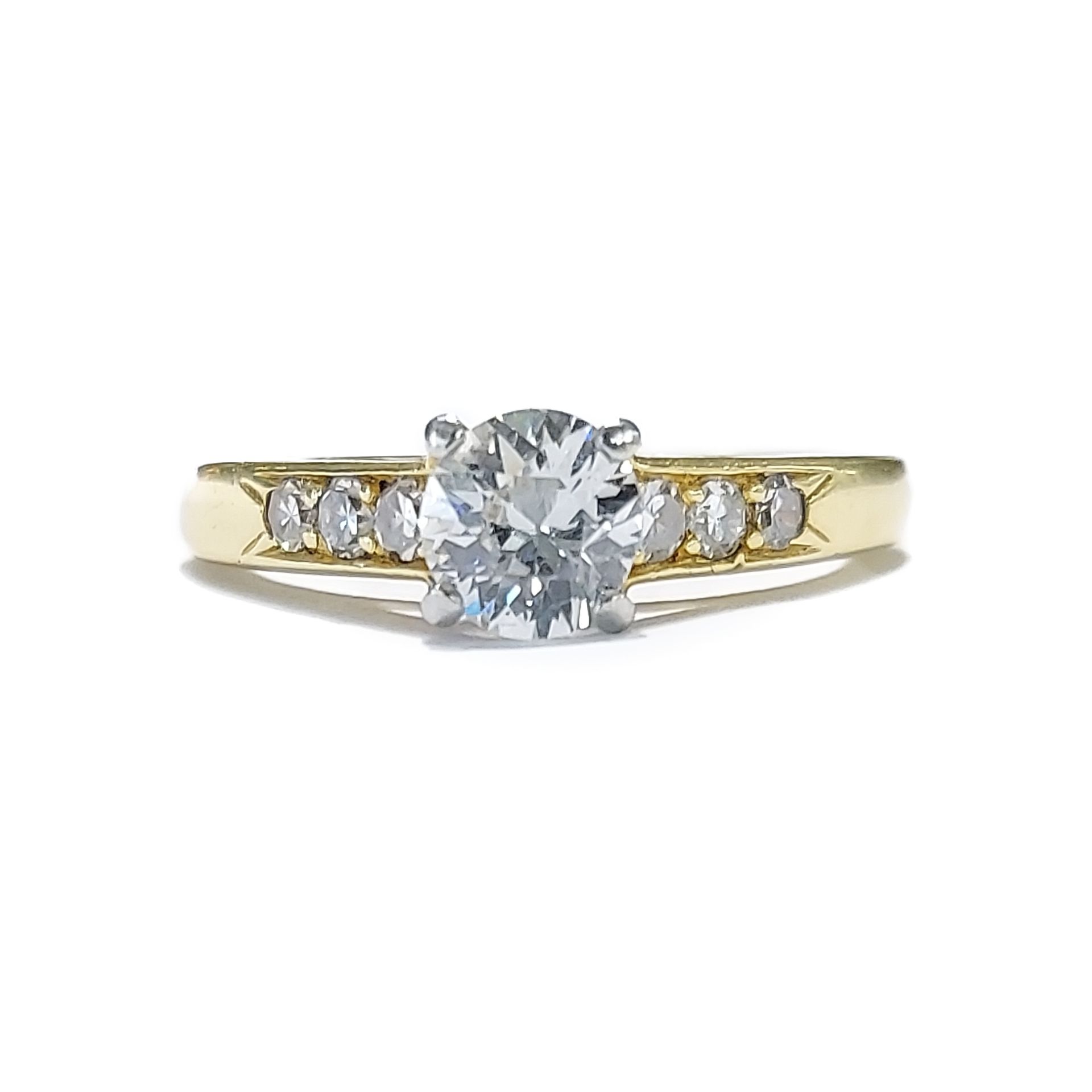 A yellow gold ring with a diamond in the center surrounded by smaller diamonds.