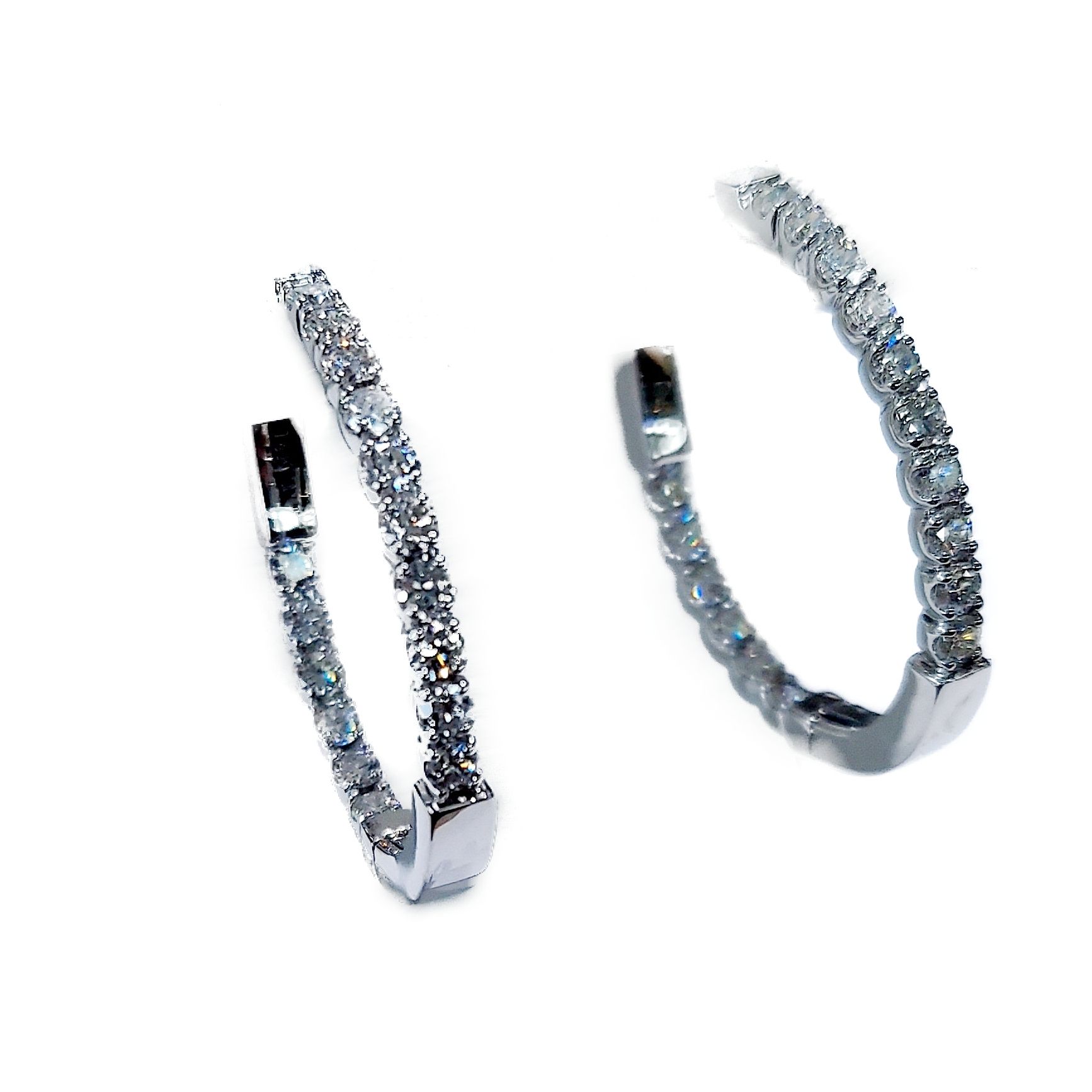 A pair of diamond hoop earrings on a white background