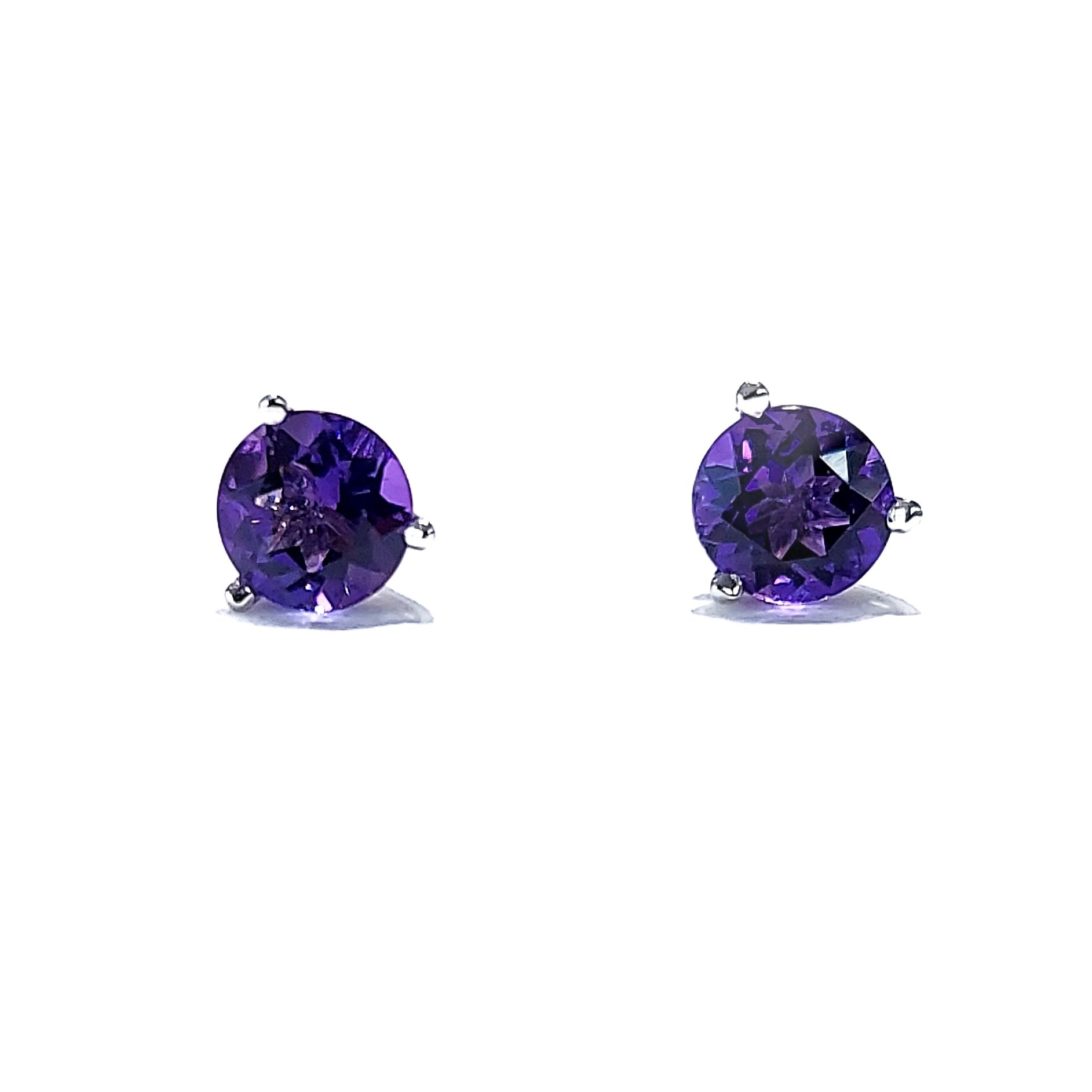 A pair of purple stud earrings on a white background