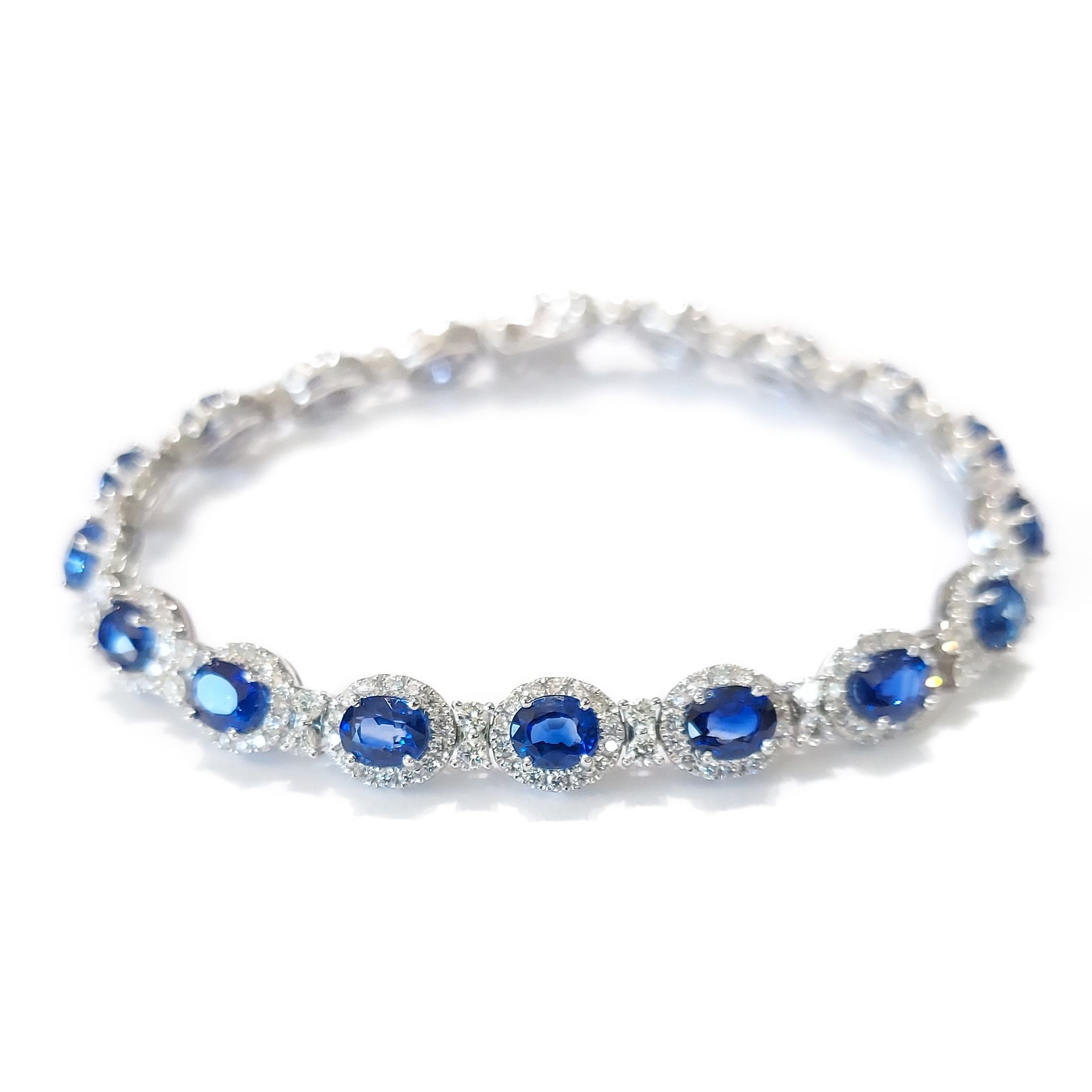 A bracelet with blue sapphires and diamonds on a white background.