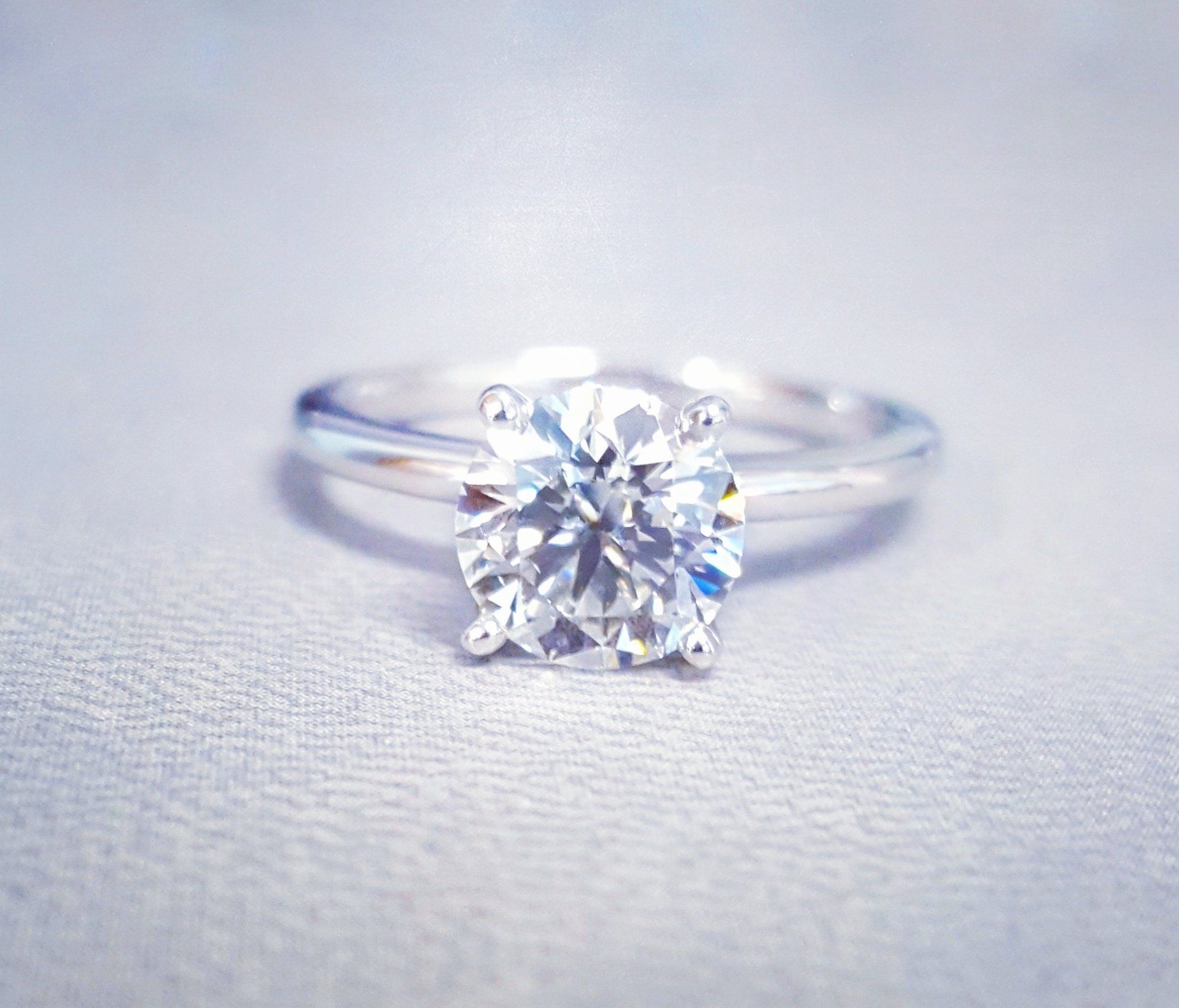 A diamond ring is sitting on a white surface