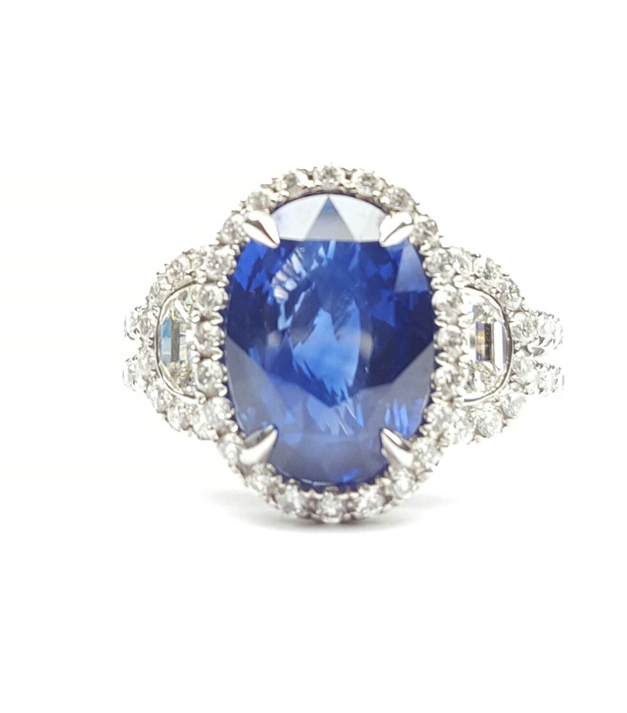 A ring with a sapphire and diamonds on a white background