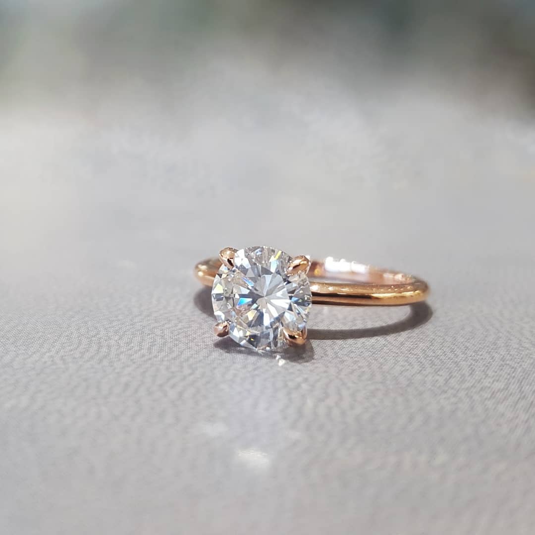 A close up of a diamond ring on a table.