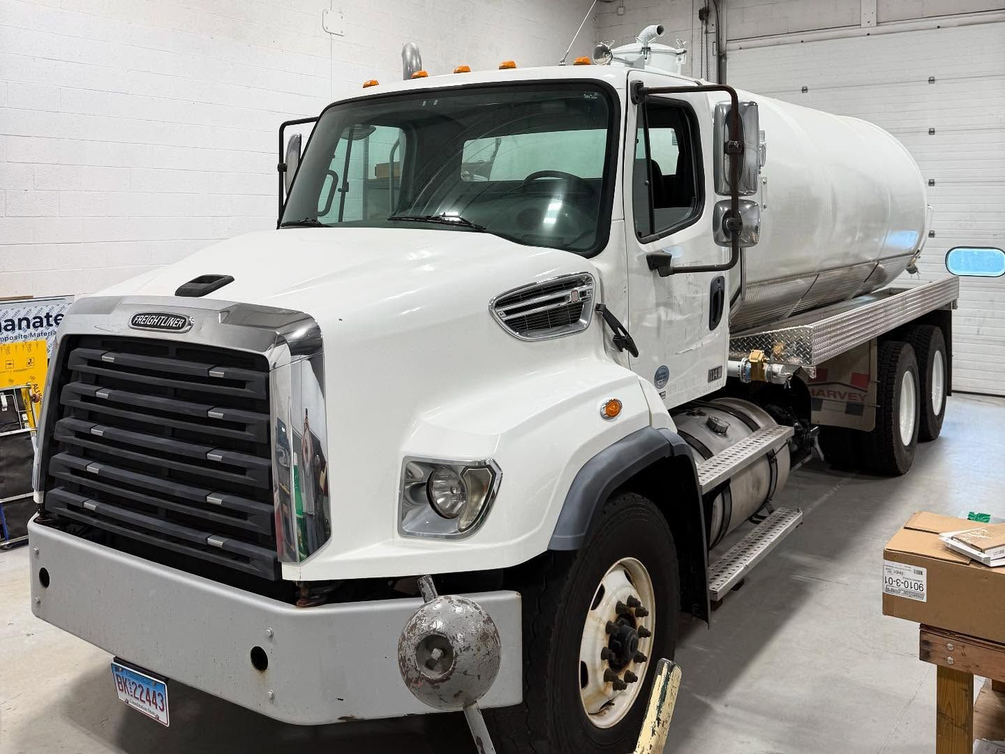 White water tanker truck parked inside a garage.
