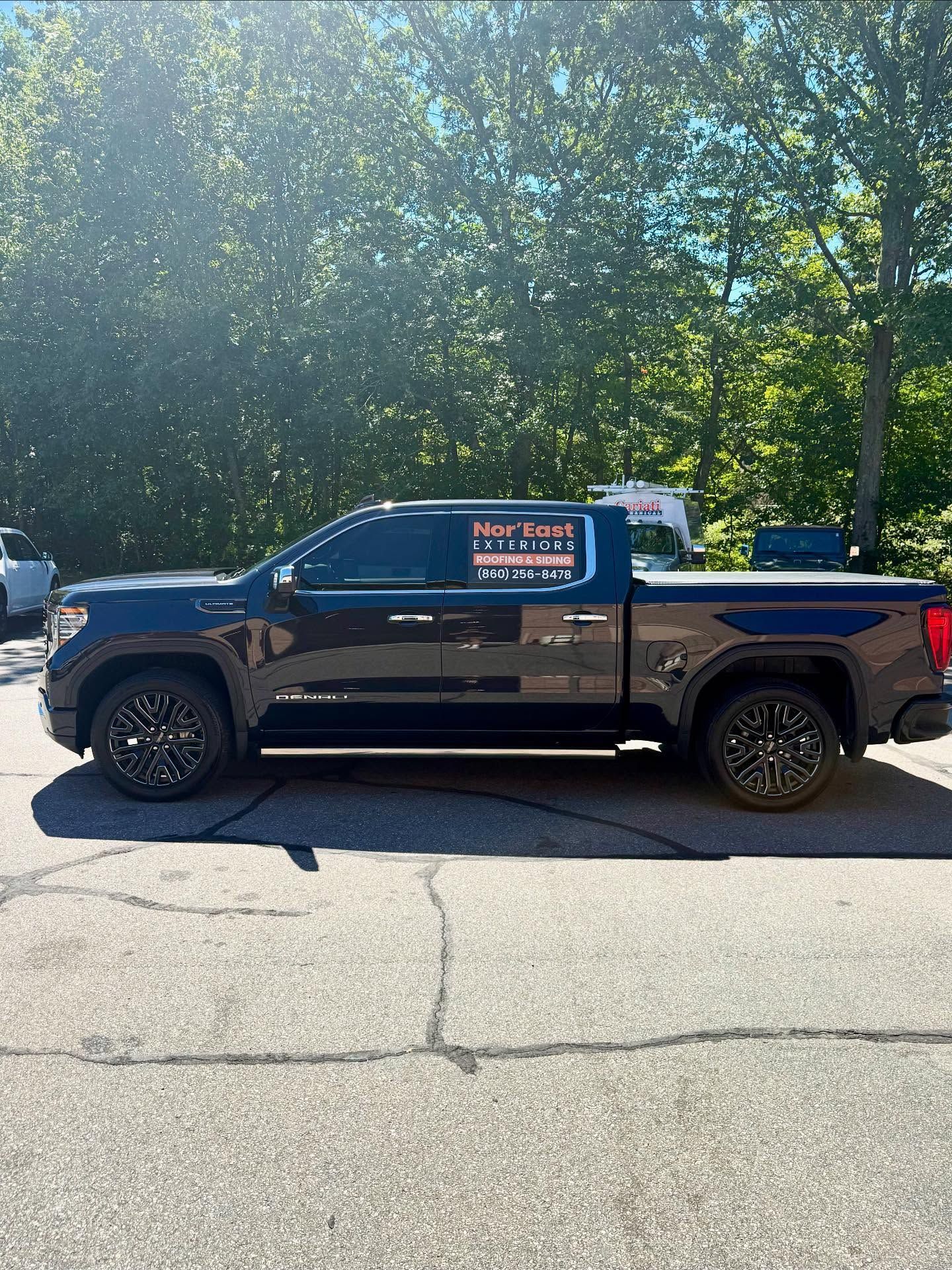 Black pickup truck with company logo parked on asphalt.