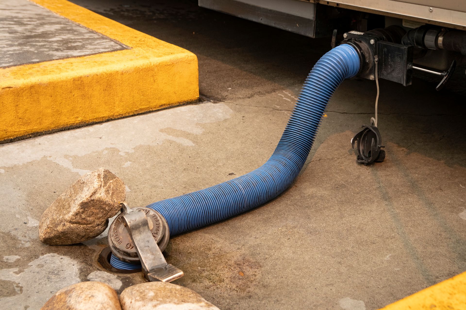 A blue hose is attached to the back of a truck.
