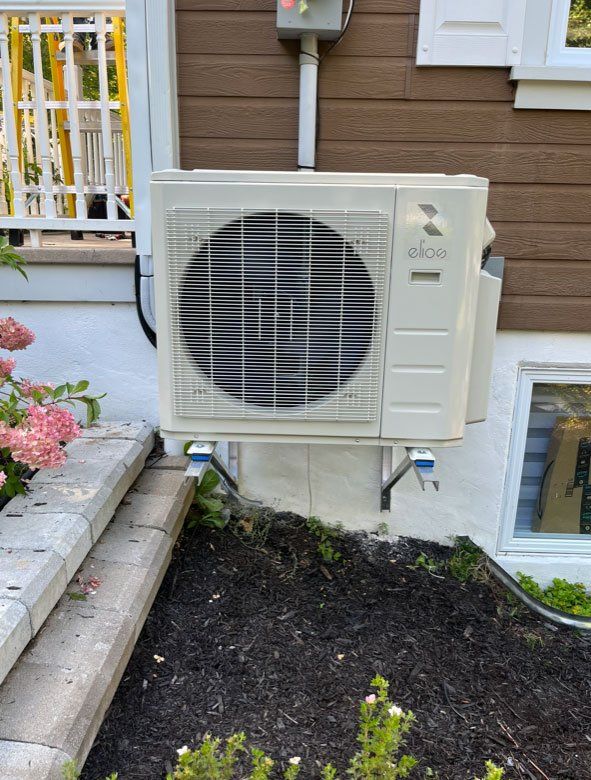 Un climatiseur blanc est monté sur le côté d'une maison.