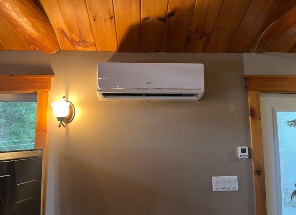 Un climatiseur blanc est monté sur un mur dans une pièce.