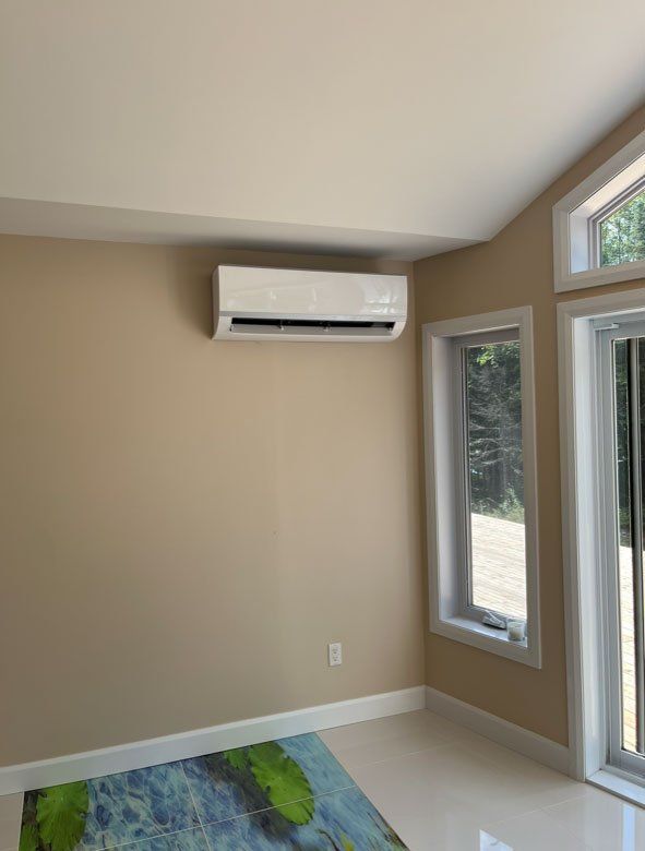 Une pièce avec une porte coulissante en verre et un climatiseur mural.