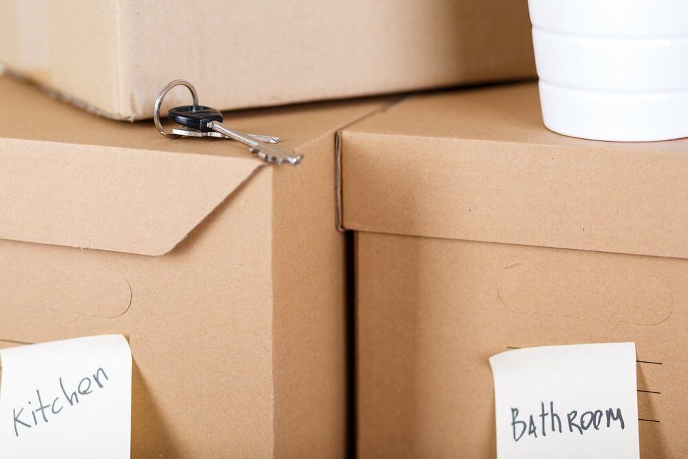 A Stack Of Cardboard Boxes With Labels For Kitchen And Bathroom — Dawson Moving & Storage NQ In Mount St John, QLD