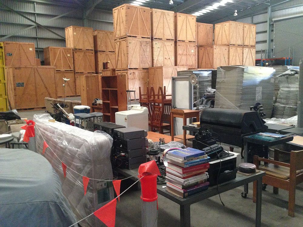 A Warehouse Storage Filled With Lots Of Boxes And Furniture — Dawson Moving & Storage NQ in Mount St John, QLD
