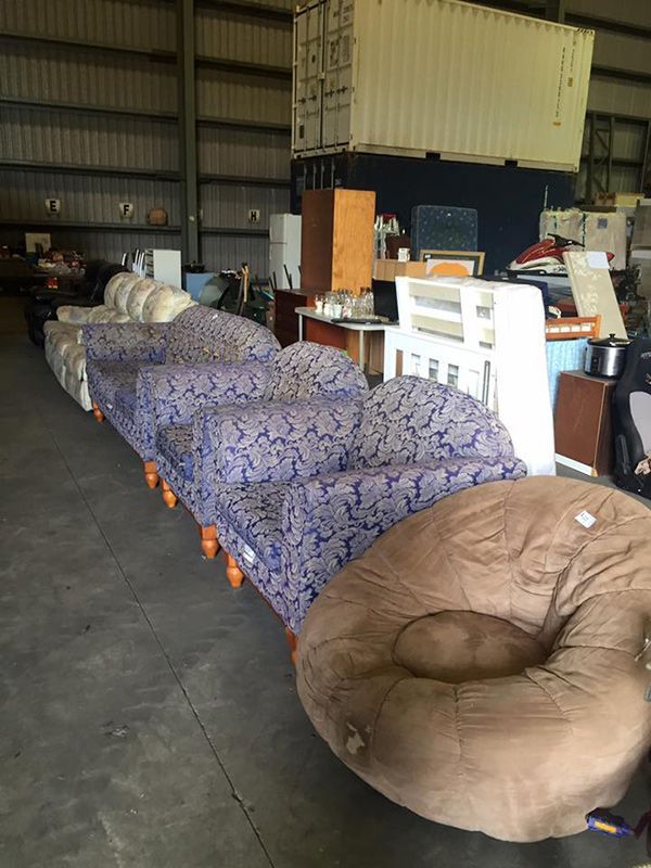 A Warehouse Filled With Furniture And A Bean Bag Chair — Dawson Moving & Storage NQ in Mount St John, QLD