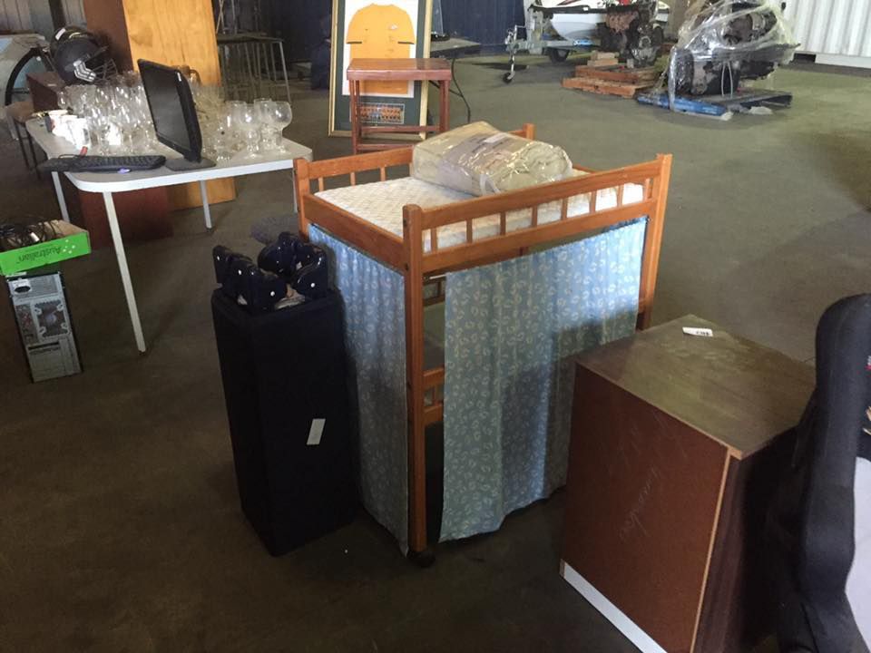 A Bunk Bed Is Sitting In A Warehouse Surrounded By Other Items — Dawson Moving & Storage NQ in Mount St John, QLD