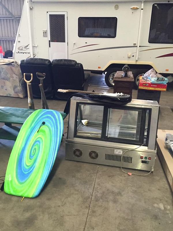 An RV Is Parked In A Garage Next To A Surfboard — Dawson Moving & Storage NQ in Mount St John, QLD