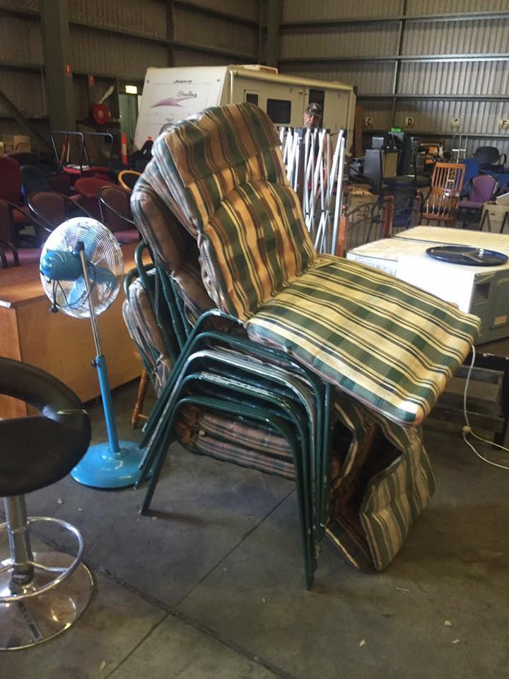 A Bunch Of Chairs Are Stacked On Top Of Each Other In A Warehouse Storage — Dawson Moving & Storage NQ in Mount St John, QLD