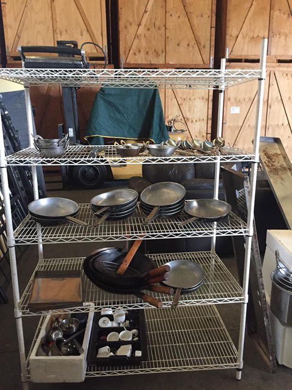 A Metal Rack Filled With Pots And Pans In A Warehouse — Dawson Moving & Storage NQ in Sydney, NSW