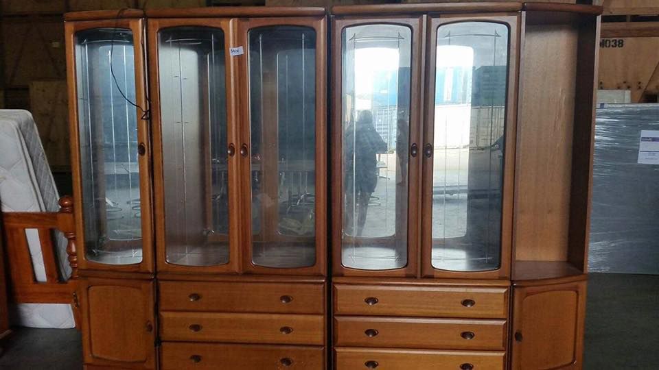 A Large Wooden Cabinet With Glass Doors And Drawers In A Room — Dawson Moving & Storage NQ in Mount St John, QLD